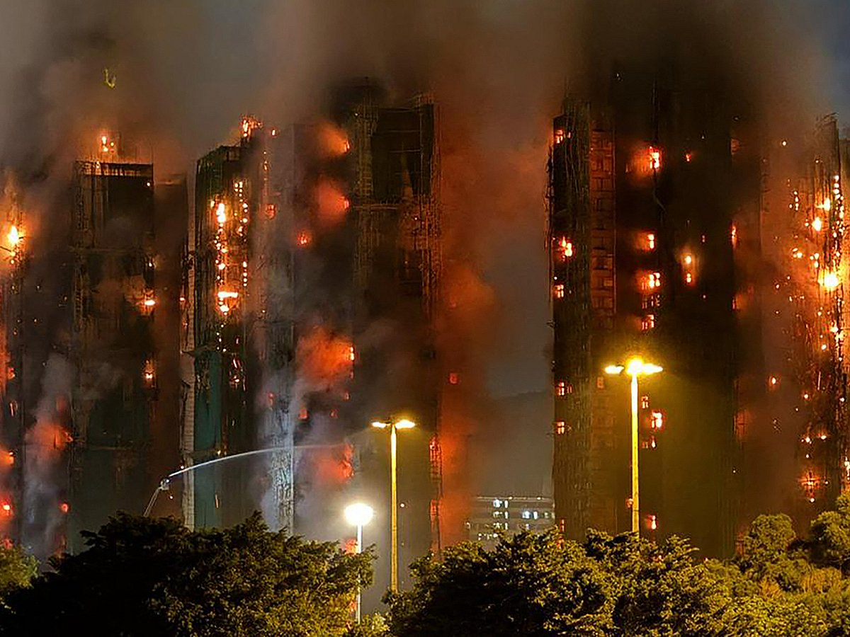 Thick smoke and flames rise as a major fire engulfs several apartment blocks at the Wang Fuk Court residential estate in Hong Kong's Tai Po district on November 26, 2025.