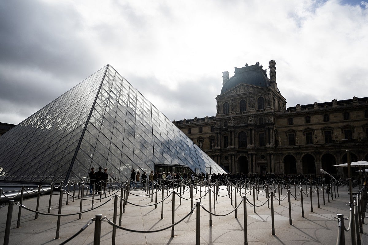 Tourists queue to enter the Louvre museum next to the Louvre pyramid designed by Chinese-US architect Ieoh Ming Pei, in Paris, on November 3, 2025.