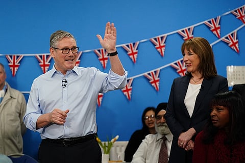 Britain's Prime Minister Keir Starmer (L) speaks with guests as Chancellor of the Exchequer Rachel Reeves (R) looks on, during a visit to the Benn Partnership community centre in Rugby, in central England on November 27, 2025, a day after his government unveiled its annual budget.