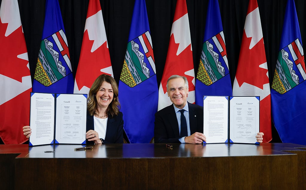 Prime Minister Mark Carney, right, signs an MOU with Alberta Premier Danielle Smith in Calgary, Alta., Thursday, Nov. 27, 2025. (Jeff McIntosh /The Canadian Press via)