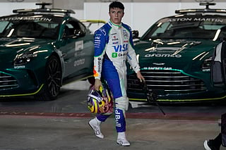 RB's French-Algerian driver Isack Hadjar walks down the pitlane during the sprint qualifying session ahead of the Formula One Qatar Grand Prix at the Lusail International Circuit in Lusail on November 28, 2025.