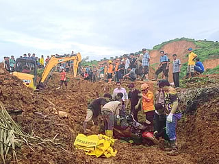 Indonesian National Search and Rescue Agency (BASARNAS), rescuers remove a scooter buried in the mud as they search for victims at a village hit by a landslide in Batu Goading, North Sumatra, Indonesia 