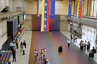 Travelers wait in the main hall of the Simon Bolivar Maiquetia International Airport in Maiquetia, Venezuela, Sunday, Nov. 23, 2025, after several international airlines canceled flights following a warning from the U.S. Federal Aviation Administration about a hazardous situation in Venezuelan airspace. (AP Photo/Ariana Cubillos)