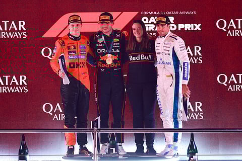 McLaren's Australian driver Oscar Piastri (L), Red Bull Racing's Dutch driver Max Verstappen (2nd-L), Red Bull Racing strategist Hannah Schmitz, (2nd-R) and Williams' Spanish driver Carlos Sainz pose for a picture on the podium after the Formula One Qatar Grand Prix at the Lusail International Circuit in Lusail on November 30, 2025.