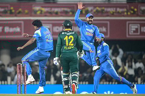 India's Harshit Rana (L) celebrates with teammate Virat Kohli (R) after taking the wicket of South Africa's Quinton de Kock (C) during the first one-day international (ODI) cricket match at the JSCA International Stadium in Ranchi on November 30, 2025.