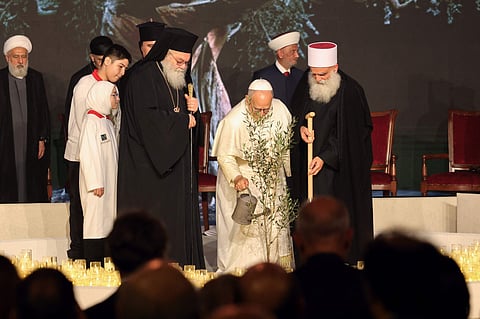 Pope Leo XIV waters an olive tree after planting it with religious leaders during an ecumenical and inter-religious meeting in Lebanon on December 1.