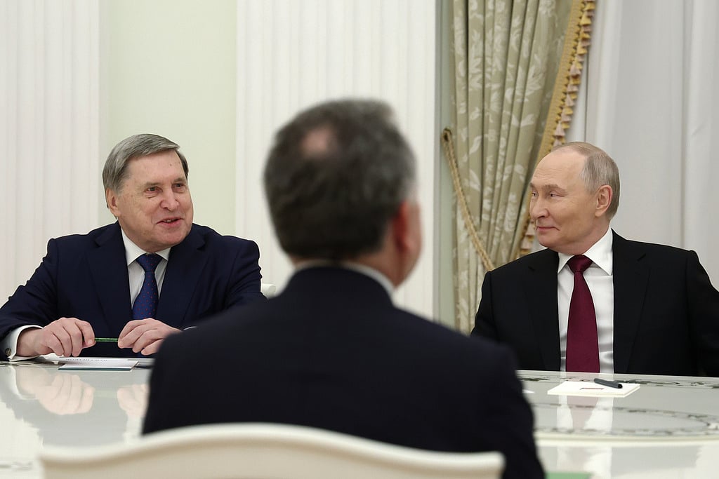 Russian President Vladimir Putin, right, and Russian Presidential foreign policy adviser Yuri Ushakov, left, attend talks with US special envoy Steve Witkoff, back to a camera, at the Senate Palace of the Kremlin in Moscow, Russia, Tuesday, Dec. 2, 2025.