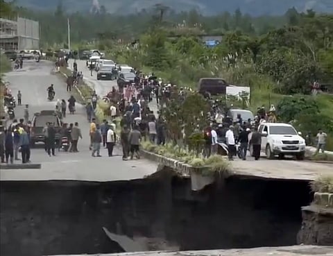 The video captured the incident showing the yawning gap on the road as chunks of asphalt and earth collapsed while people looked on during one of Southeast Asia's most devastating natural disasters.