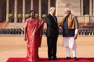 Russia's President Vladimir Putin shakes hands with India's Prime Minister Narendra Modi as Indian President Droupadi Murmu stands nearby during the Russian leader's ceremonial reception at India's presidential palace, Rashtrapati Bhavan, in New Delhi on December 5, 2025.