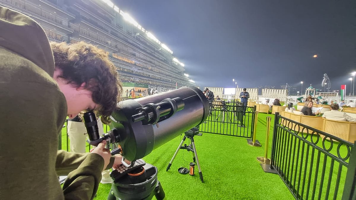 An astronomy enthusiast captures the Cold Moon 2025 through DAG's telescope at the Paddock Garden of Meydan Racecourse on Friday. 