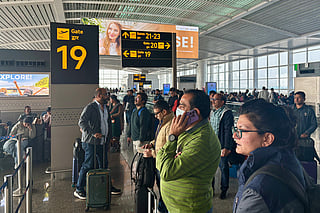 Passengers wait outside the Indira Gandhi International Airport in New Delhi, India.