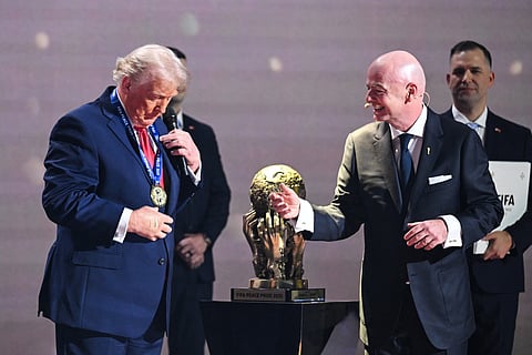US President Donald Trump reacts as he receives the FIFA Peace Prize from Italian Fifa President Gianni Infantino during the draw for the 2026 FIFA Football World Cup taking place in the US, Canada and Mexico, at the Kennedy Center, in Washington, DC, on December 5, 2025.