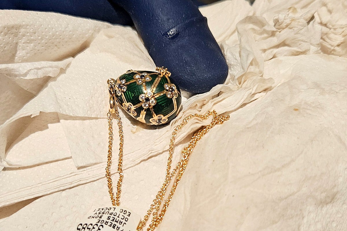 This handout photo release by New Zealand Police on December 5, 2025 shows an officer displaying a recovered diamond-encrusted green Fabergé egg in Auckland after keeping a six-day watch over the thief accused of swallowing it.