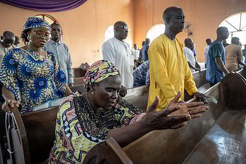 Worshippers pray at the Evangelical Church Winning All (ECWA) during a prayer called by the Christian Association of Nigeria (CAN) in Minna on December 7, 2025.