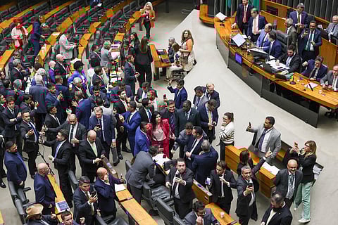 Lawmakers of Brazil's lower house of Congress celebrate after approving a bill that could slash former president Jair Bolsonaro's prison sentence for plotting a coup, in Brasilia on December 10, 2025.