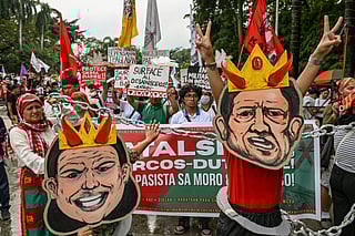Protesters wearing masks depicting the faces of Philippines' President Ferdinand Marcos Jr. and Philippines' Vice President Sara Duterte march during a protest held to mark the International Human Rights Day in Manila on December 10, 2025.