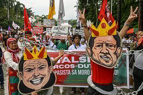 Protesters wearing masks depicting the faces of Philippines' President Ferdinand Marcos Jr. and Philippines' Vice President Sara Duterte march during a protest held to mark the International Human Rights Day in Manila on December 10, 2025.