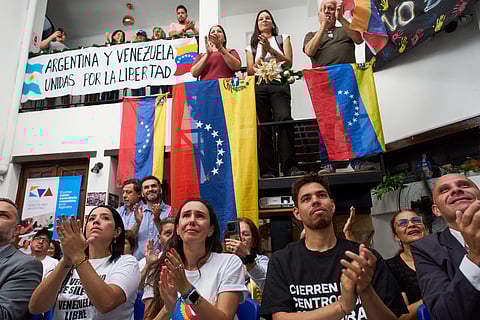 People applaud while watching the ceremony of the Nobel Peace Prize for Venezuelan opposition leader Maria Corina Machado in Norway, during a live viewing in Buenos Aires, Argentina, Wednesday, Dec. 10, 2025. 