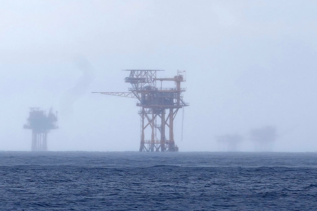 FILE - Oil platforms are visible through the haze near the Flower Garden Banks National Marine Sanctuary in the Gulf of Mexico, off the coast of Galveston, Texas, Saturday, Sept. 16, 2023.