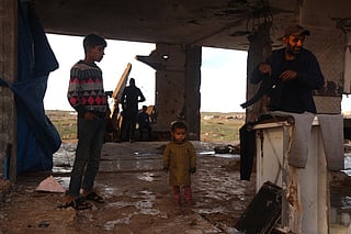 Displaced Palestinians who lost their homes in the Gaza war, shelter in the remains of a building following heavy rains in the Nuseirat refugee camp in the central Gaza Strip, on December 13, 2025.