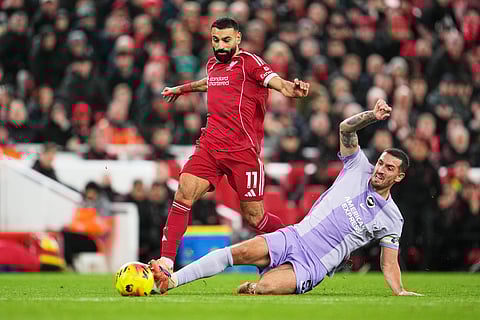 Liverpool's Mohamed Salah, left, challenges for the ball with Brighton's Lewis Dunk during the English Premier League soccer match between Liverpool and Brighton and Hove Albion in Liverpool, England, Saturday, Dec. 13, 2025.