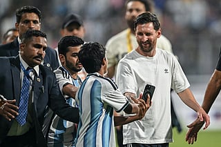 Argentina's footballer Lionel Messi (R) interacts with a young fan during his GOAT Tour at the Wankhede Stadium in Mumbai on December 14, 2025.