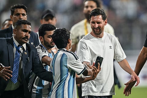 Argentina's footballer Lionel Messi (R) interacts with a young fan during his GOAT Tour at the Wankhede Stadium in Mumbai on December 14, 2025.