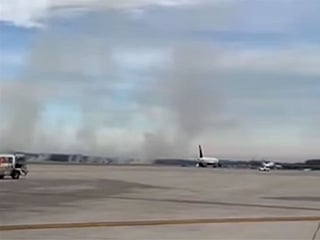 A piece of the engine cover sparked a brush fire on the ground near the airport.