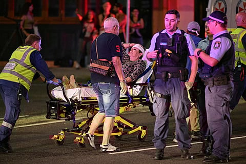 Health workers move a woman on a stretcher to an ambulance after a shooting incident at Bondi Beach in Sydney on December 14, 2025.