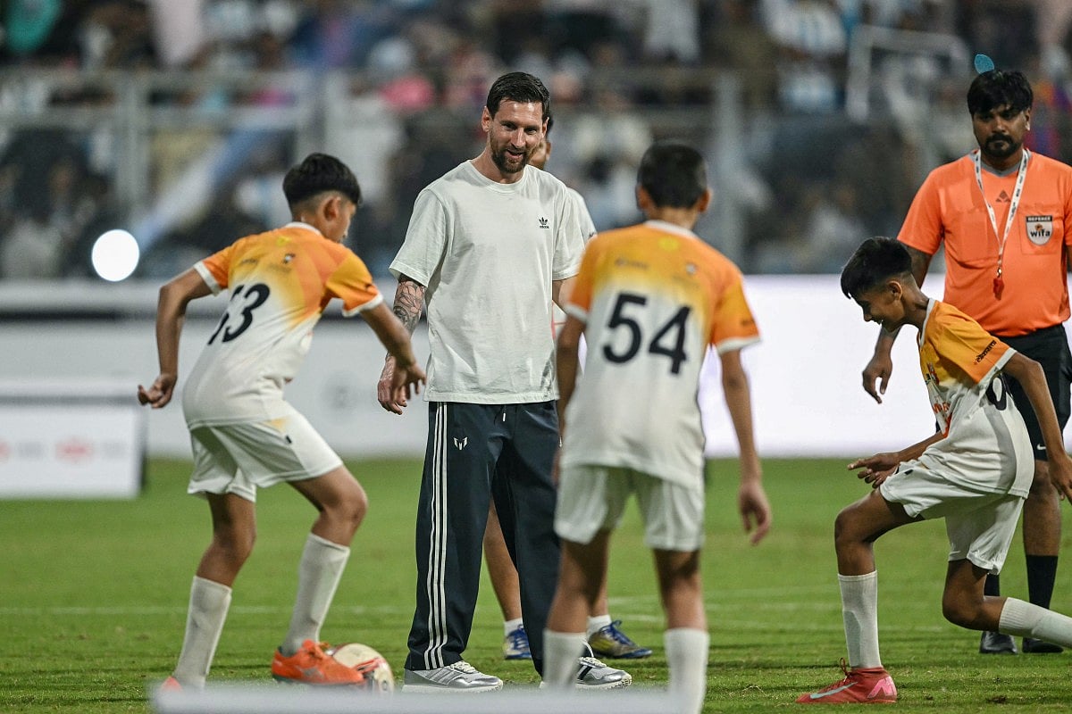 Argentina's footballer Lionel Messi (2L) plays football with children during his GOAT Tour at the Wankhede Stadium in Mumbai on December 14, 2025.