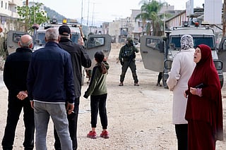 Palestinians rally as Israeli soldiers block the entrance of the Nur Shams Palestinian refugee camp, in the Israeli-occupied northern West Bank on December 15, 2025, as they demand to be allowed back to their homes after the Israeli army expelled them and others in early 2025.