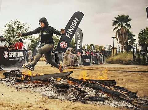 Dr Mariam Al Blooshi jumping over fire at the Spartan race.