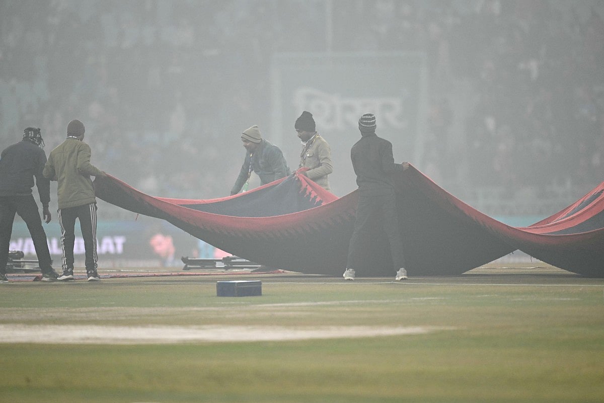 Groundsmen cover the pitch during the fourth Twenty20 international cricket match between India and South Africa at the Ekana Cricket Stadium in Lucknow on December 17, 2025.