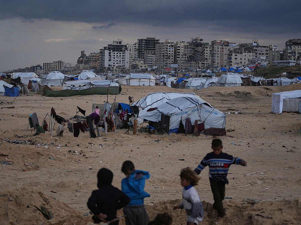 Palestinian children play next to tents in a makeshift camp for displaced people set up on the beach in Gaza City.