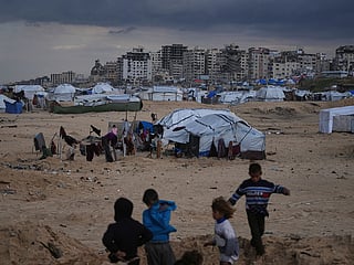 Palestinian children play next to tents in a makeshift camp for displaced people set up on the beach in Gaza City.