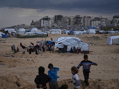 Palestinian children play next to tents in a makeshift camp for displaced people set up on the beach in Gaza City.