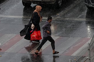 Residents caught in the rain at Al Majaz in Sharjah on Thursday.