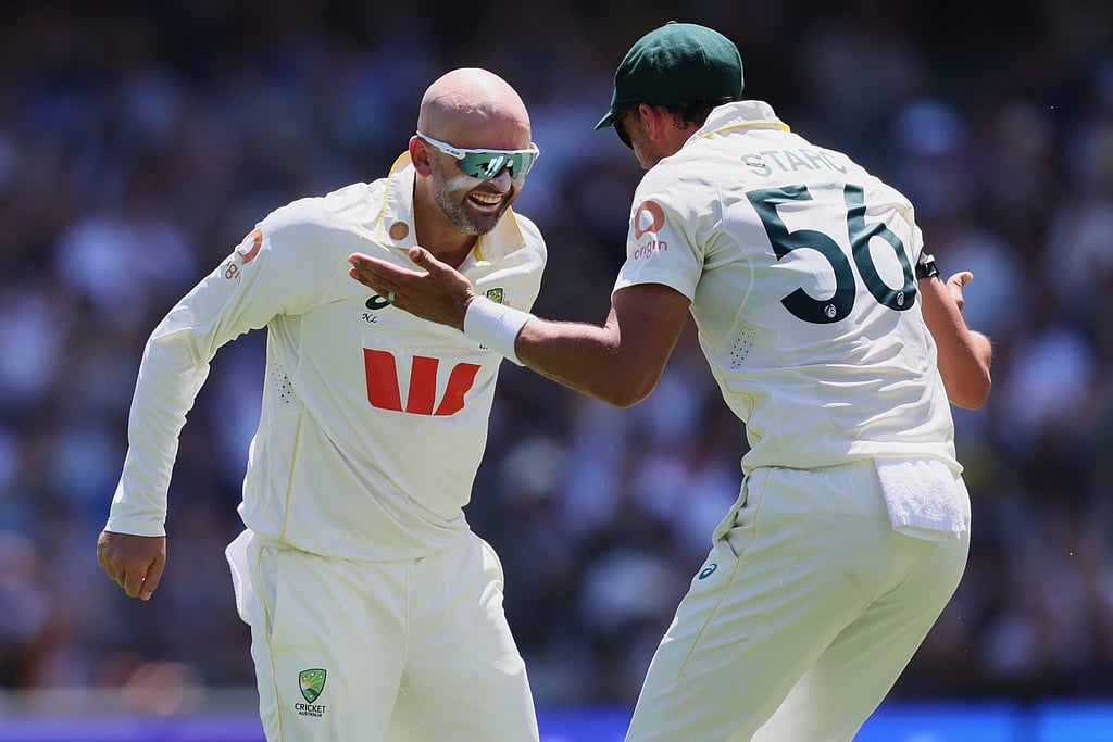 Australia's Nathan Lyon, left, celebrates with teammate Mitchell Starc after dismissing England's Ben Duckett during play on day two of the third Ashes cricket test between England and Australia in Adelaide, Australia, Thursday, Dec. 18, 2025.