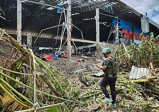 This handout photo made available by Agence Kampuchea Press (AKP) on December 18, 2025 shows a man inspecting a garage damaged after Thai air strikes in Poipet town, Banteay Meanchey province, amid clashes along the Cambodia-Thailand border.