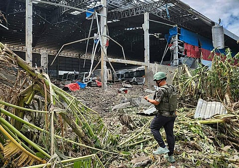 This handout photo made available by Agence Kampuchea Press (AKP) on December 18, 2025 shows a man inspecting a garage damaged after Thai air strikes in Poipet town, Banteay Meanchey province, amid clashes along the Cambodia-Thailand border.