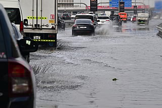 Vehicles drive on a flooded road during heavy rain in Dubai on Thursday, December 18, 2025.