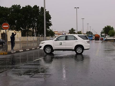 A Sharjah City Municipality patrol comes to the aid of residents in the rain.