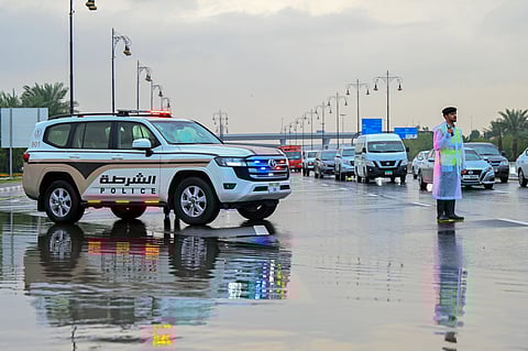 Sharjah Police control the traffic during the rain.