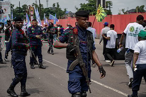 Police officers patrol as demonstrators take part in the peaceful march organised by the Sacred Union of the Nation in Kinshasa on December 19, 2025 to express support for Congolese institutions, the Armed Forces of the Democratic Republic of Congo (FARDC) and the Wazalendo, and to denounce the Rwandan aggression in eastern DR Congo, and affirm attachment to national sovereignty.