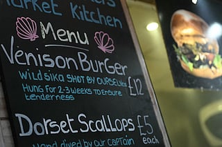 This photo taken on December 18, 2025 shows a signage offering venison burgers at a popular market in London.