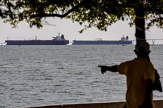 A man watches two crude oil tankers remaining anchored on Lake Maracaibo, near Maracaibo, Zulia state, Venezuela on December 17, 2025.