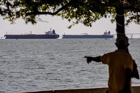 A man watches two crude oil tankers remaining anchored on Lake Maracaibo, near Maracaibo, Zulia state, Venezuela on December 17, 2025.