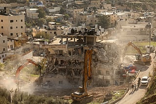 Excavators demolish a building constructed without a permit in the Wadi Qaddum area near the Silwan neighbourhood of east Jerusalem on December 22, 2025.