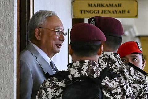 Jailed former prime minister of Malaysia Najib Razak (L) arrives for a court hearing where he seeks to land a ruling allowing him serve the rest of his six-year sentence under house arrest instead of in the Kajang Prison, at the Kuala Lumpur High Court in Kuala Lumpur on December 22, 2025.
