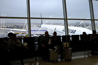 Passengers wait to board a flight at JFK International Airport in New York on December 23, 2025.